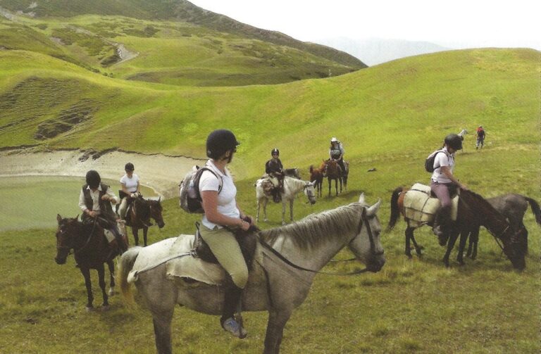 Groep ruiters op groene berghellingen in Tusheti, Georgië